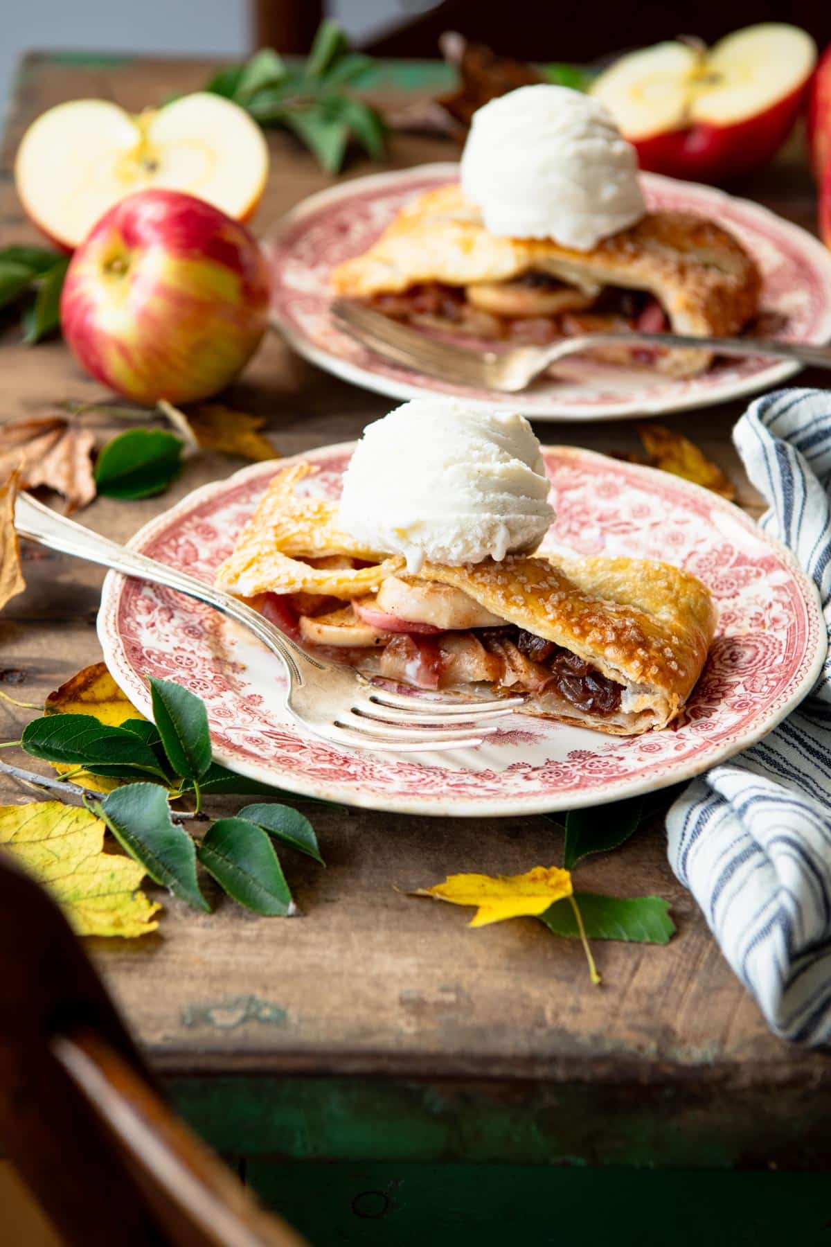 Two pieces of easy apple strudel recipe on a wooden table with vanilla ice cream.