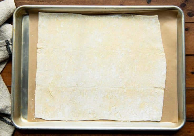 Puff pastry rolled out onto a baking sheet.