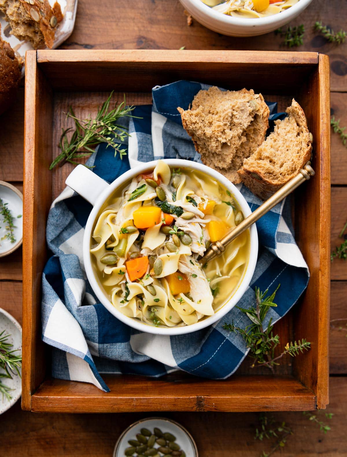 Wooden tray with a mug of easy chicken noodle soup.