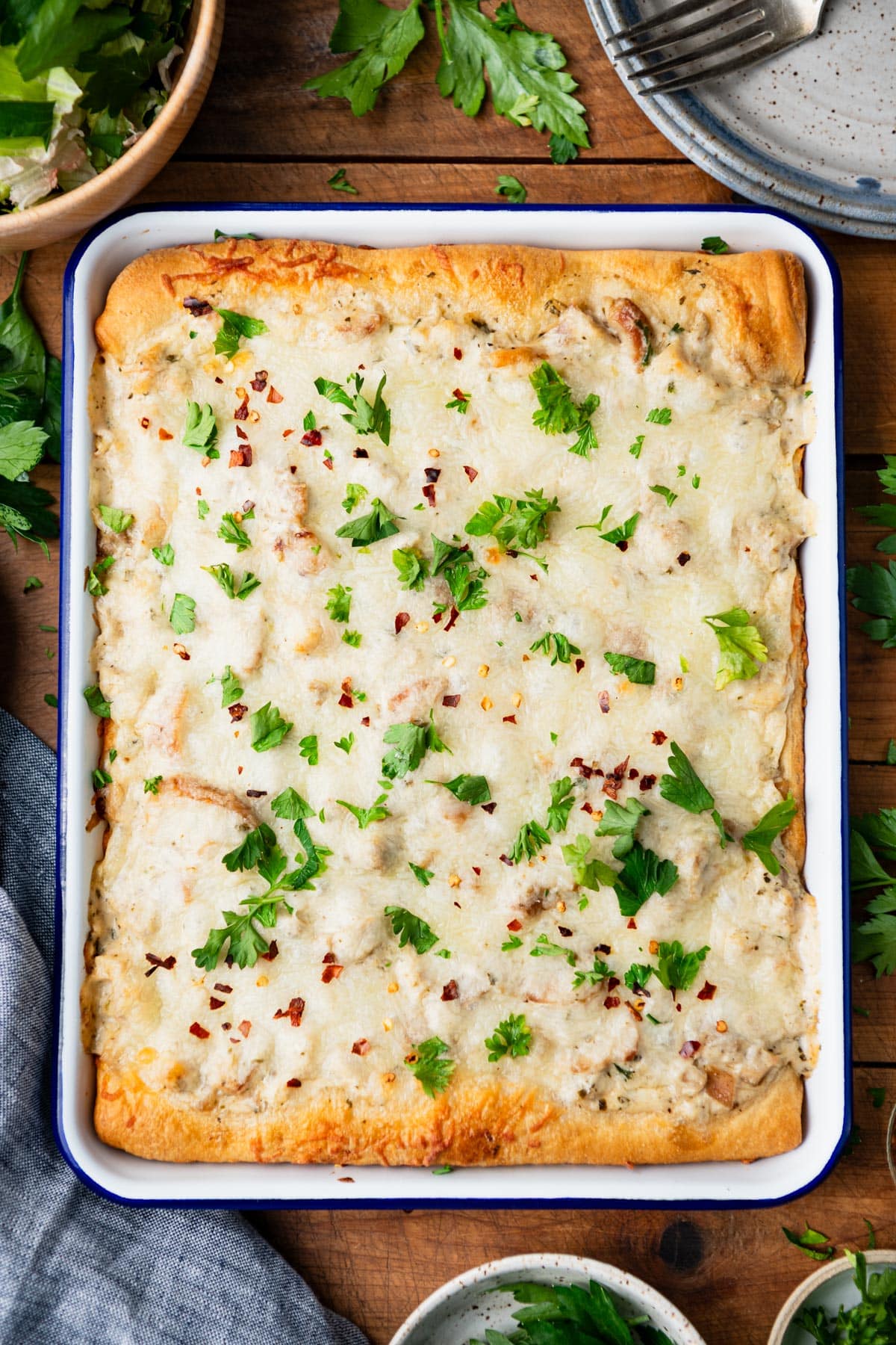 Overhead image of chicken alfredo crescent roll casserole in a baking dish on a table.