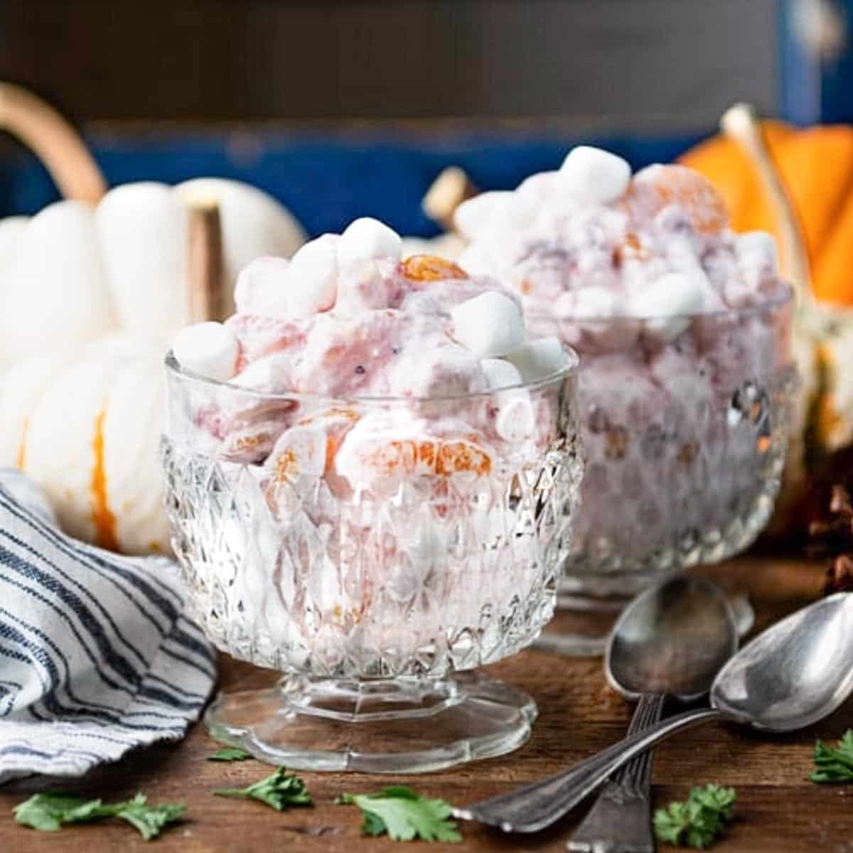 Square side shot of cranberry fluff salad in two glass bowls.