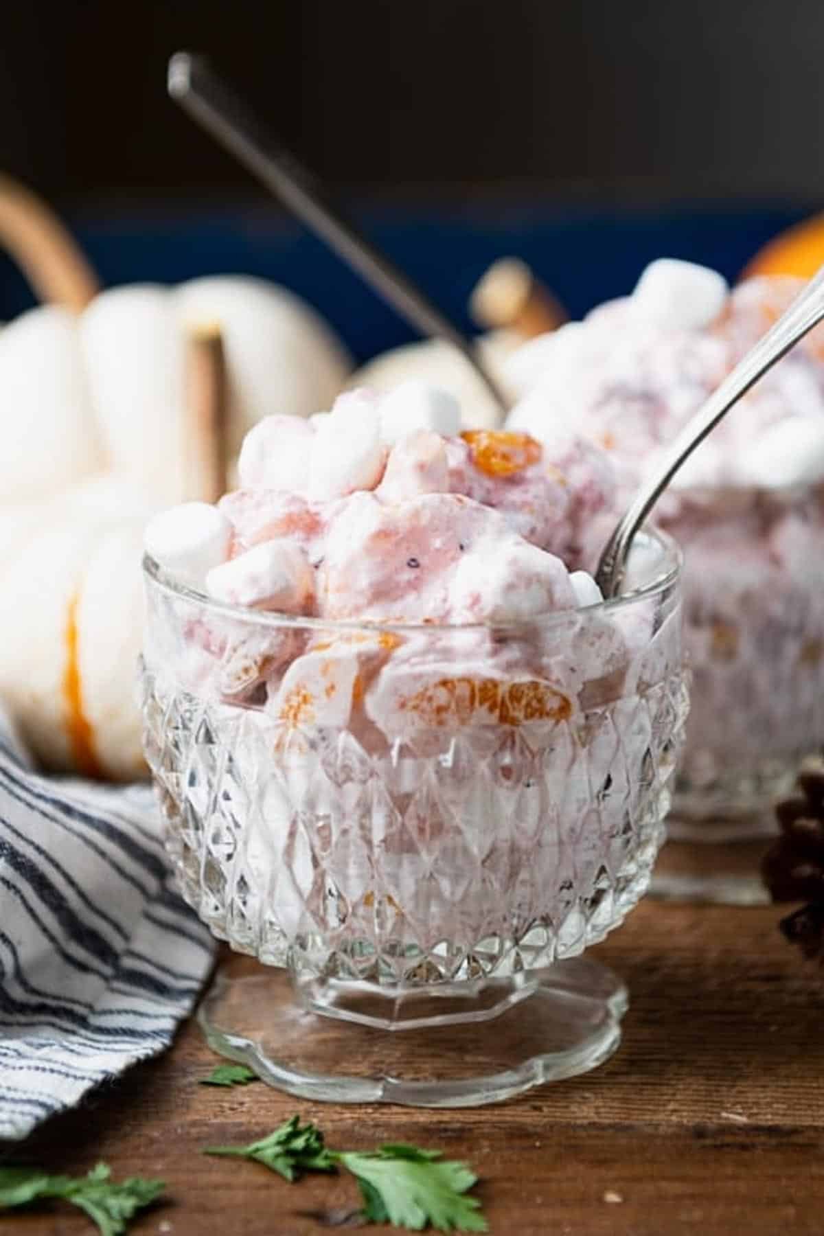 Spoons in two bowls of cranberry fluff salad.