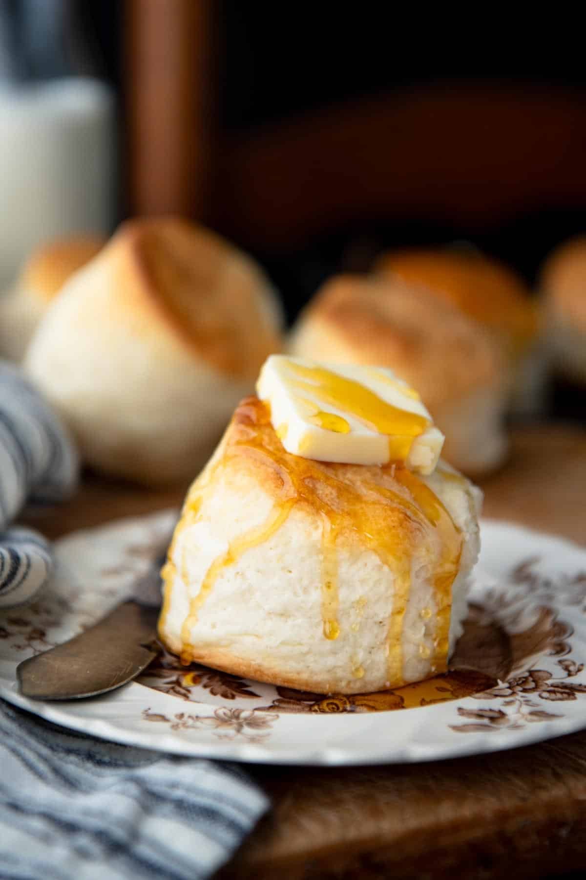Cream biscuits on a plate drizzled with honey.