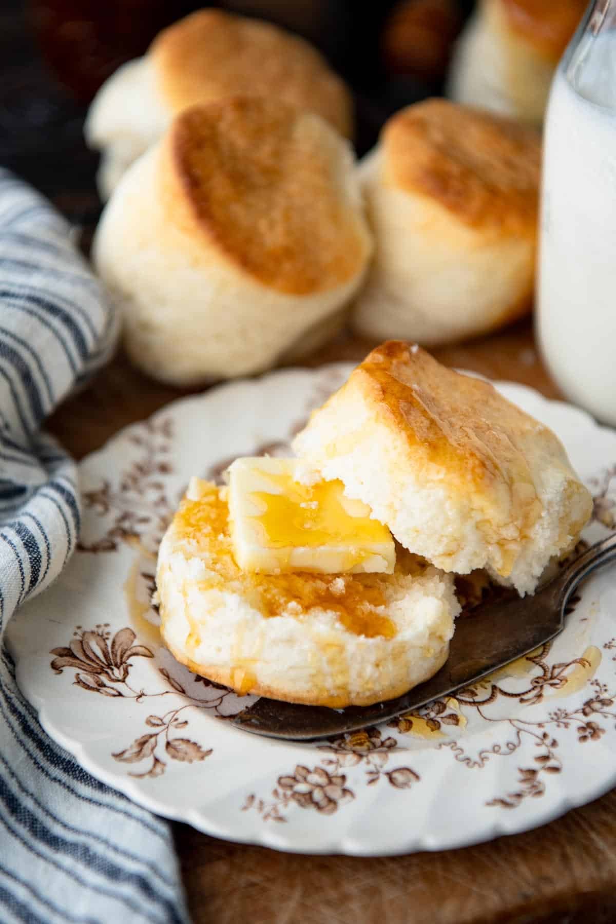 Cream biscuits on a plate with butter and honey.