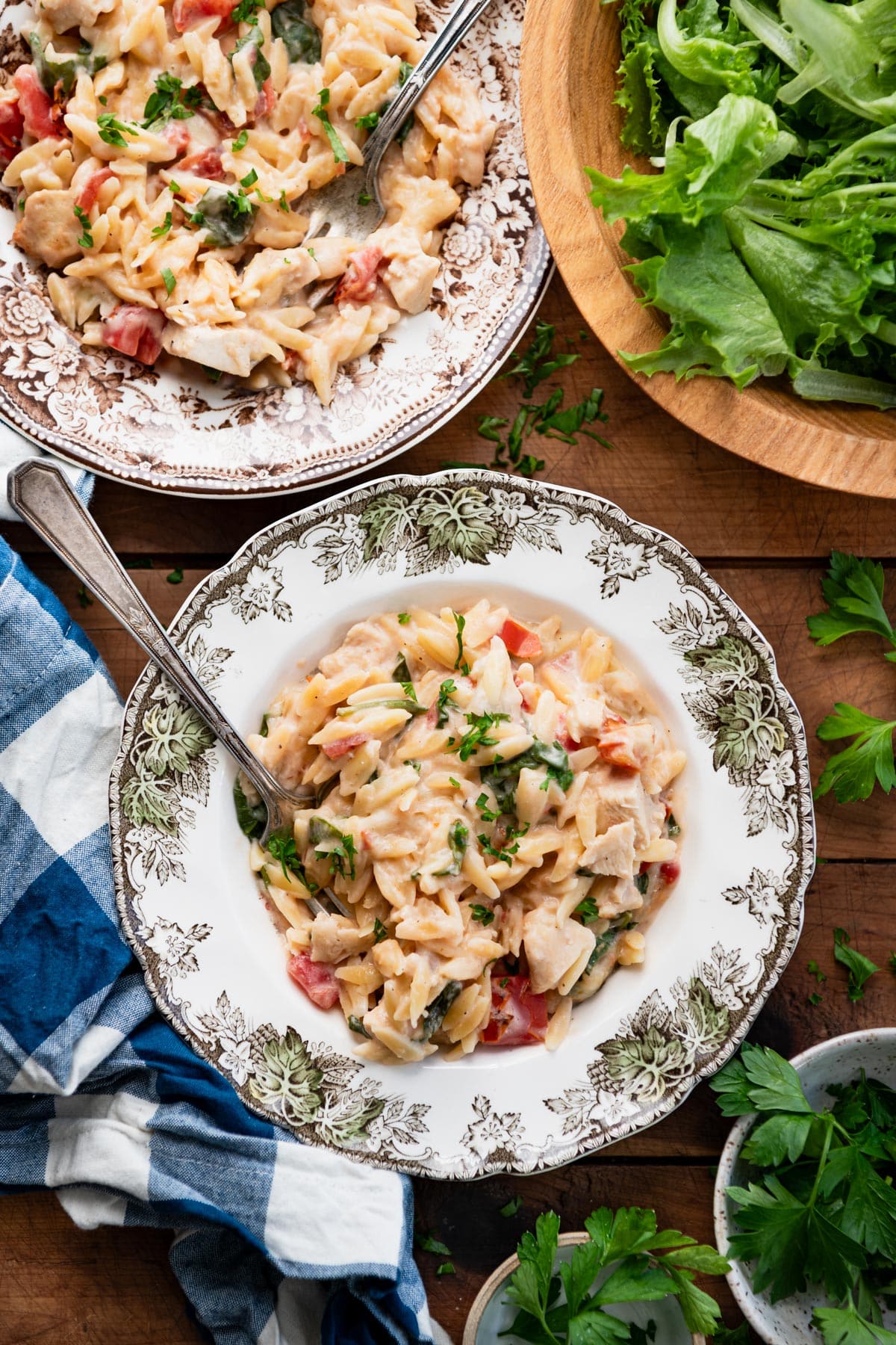 Two bowls of the best chicken orzo recipe on a wooden dinner table.