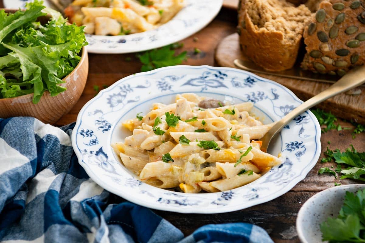 Horizontal side shot of a bowl of creamy chicken penne pasta casserole.