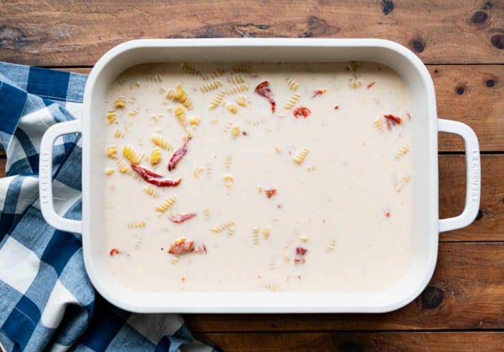Sun-dried tomato pasta ingredients stirred together before baking.