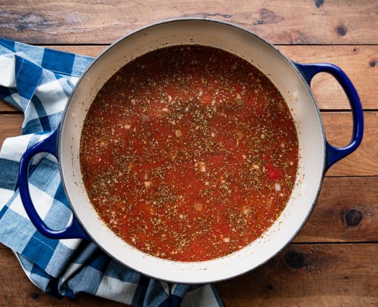 Process shot showing how to make Italian sausage tortellini soup.