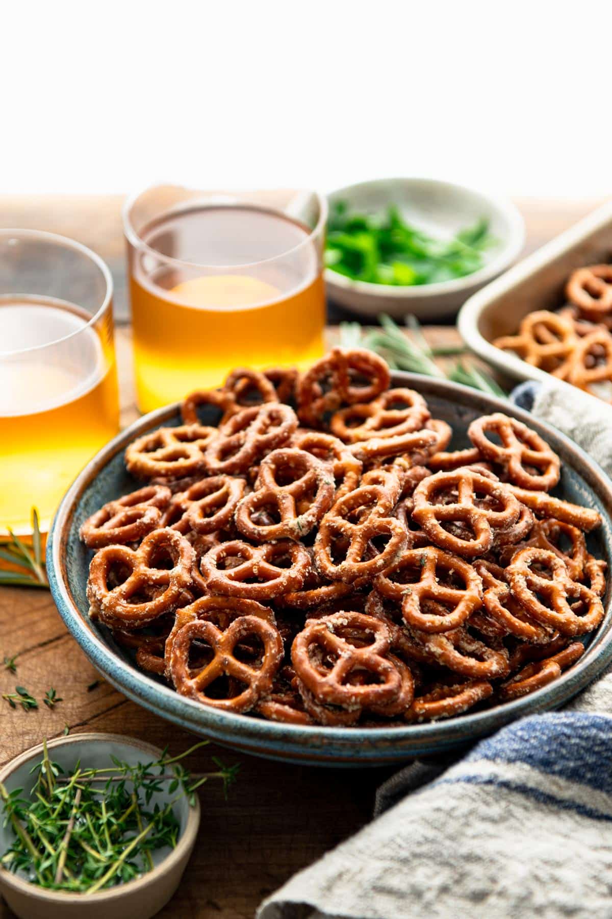 Side shot of baked ranch pretzels on a table with beer.