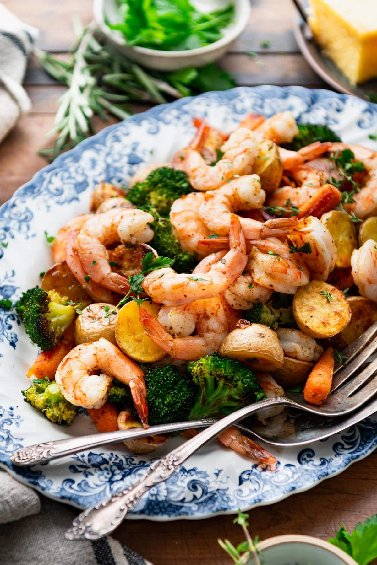Close up side shot of a platter of sheet pan shrimp and vegetables.