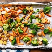 Adding broccoli to sheet pan dinner recipe.