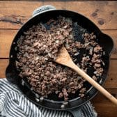 Browning ground beef and onion in a cast iron skillet.