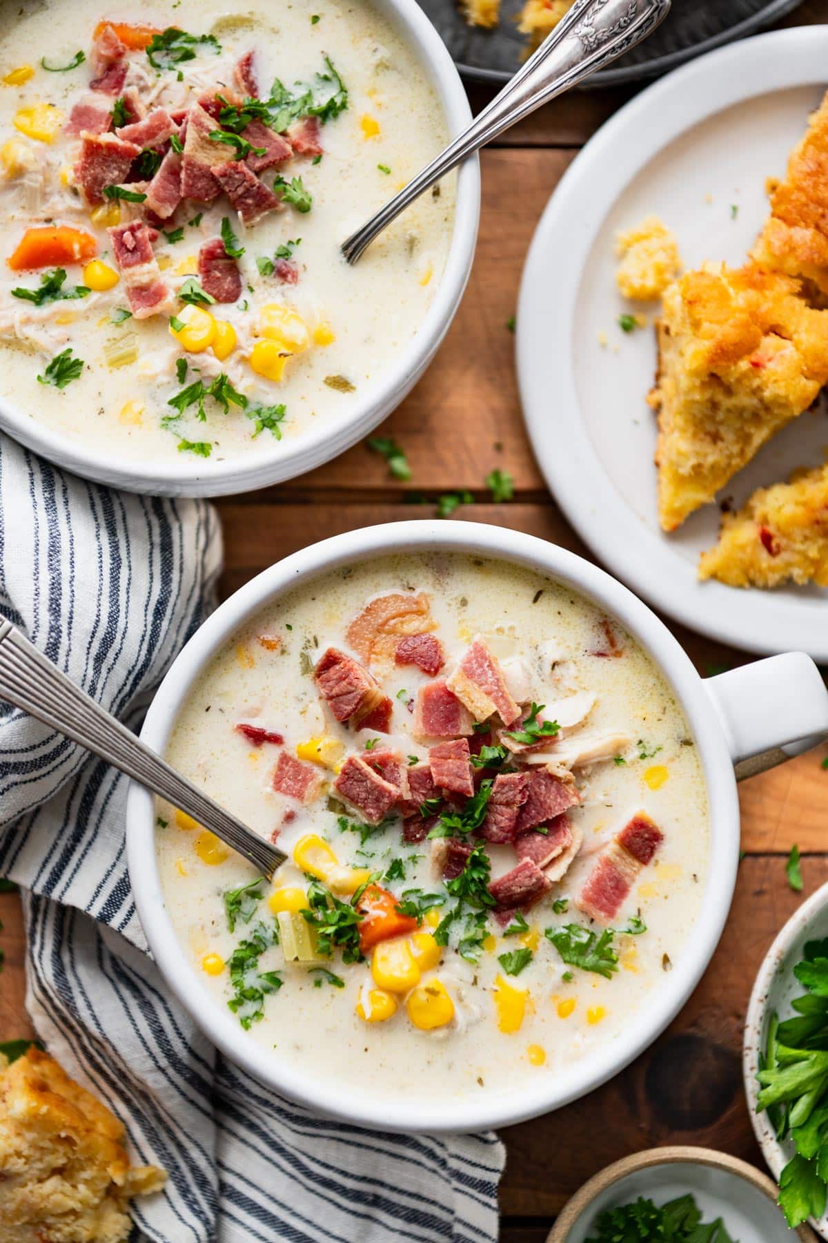 Two bowls of an easy chicken corn soup recipe served with a side of cornbread.