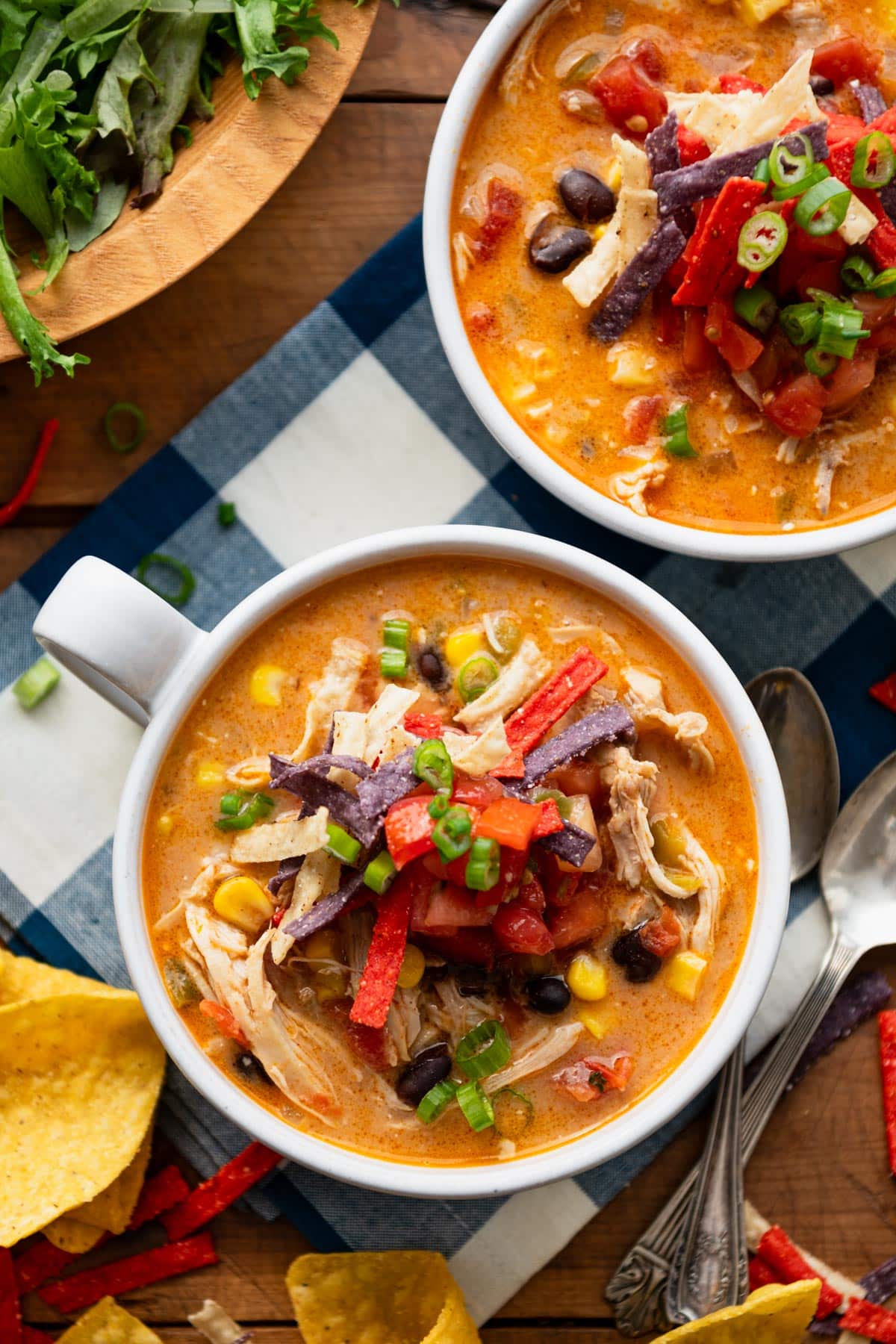 Overhead image of the best chicken enchilada soup recipe in white bowls on a table.