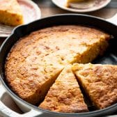 Side shot of Jiffy cornbread with creamed corn and pimento cheese in a cast iron skillet.