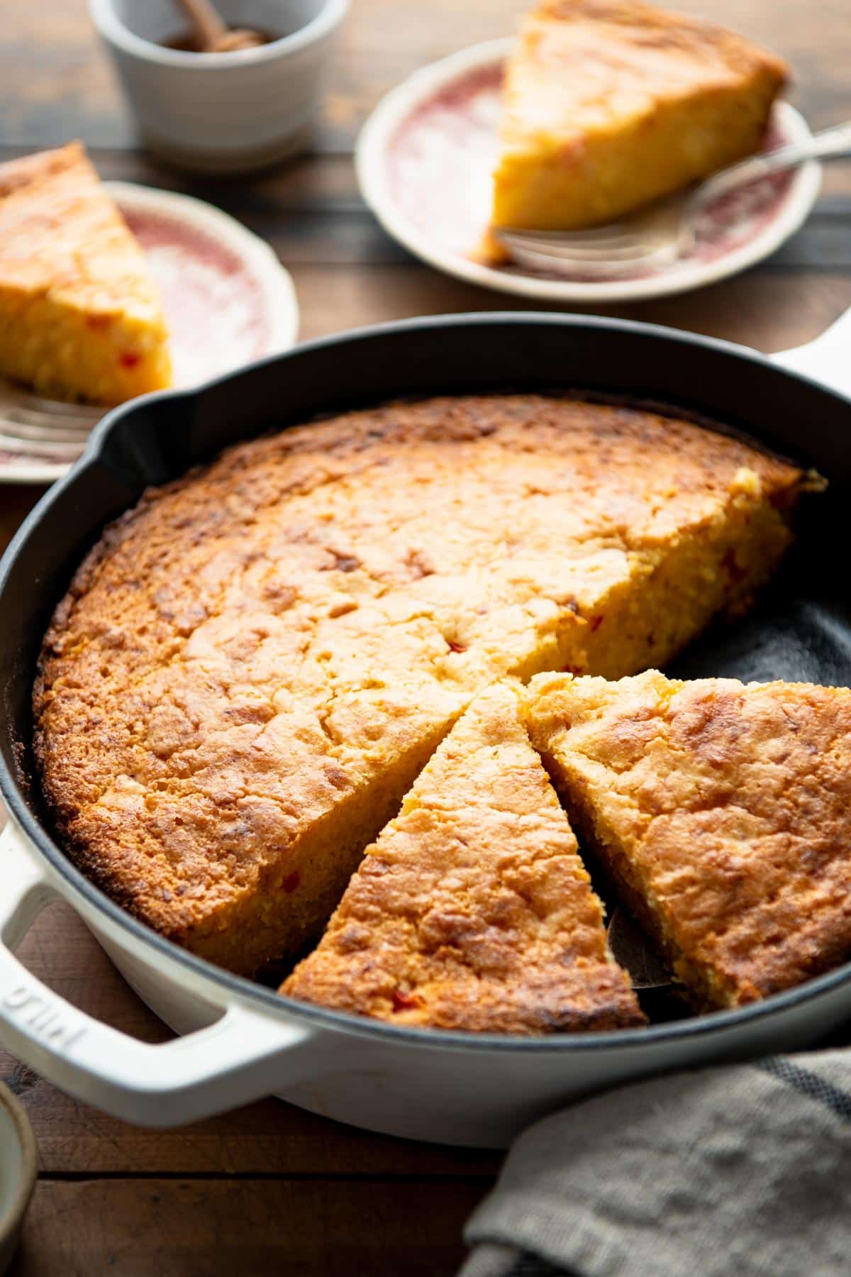 Side shot of Jiffy cornbread with creamed corn and pimento cheese in a cast iron skillet.