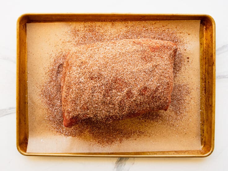 Seasoning a pork shoulder with homemade bbq rub.