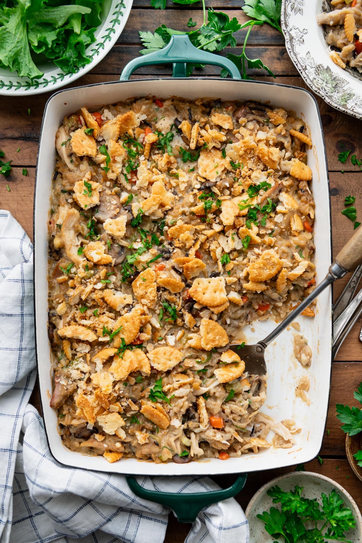 Overhead image of chicken and wild rice casserole in a baking dish on a wooden table.