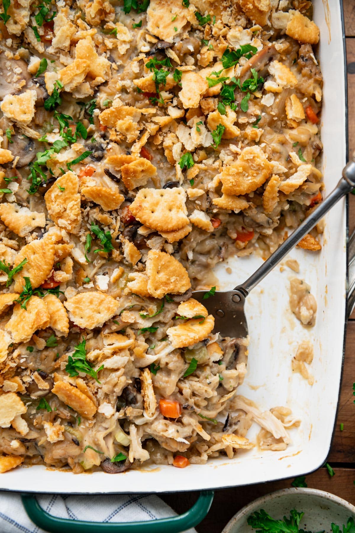 Close overhead shot of a serving spoon in a dish of wild rice and chicken casserole.