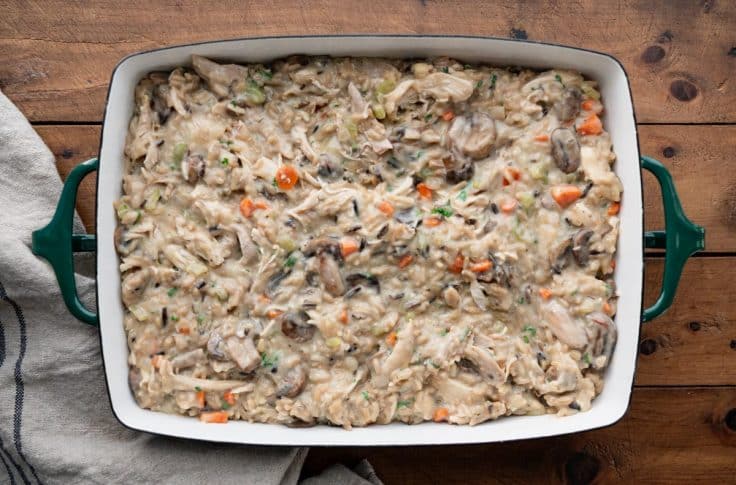 Chicken and wild rice casserole in a dish before adding topping and baking.