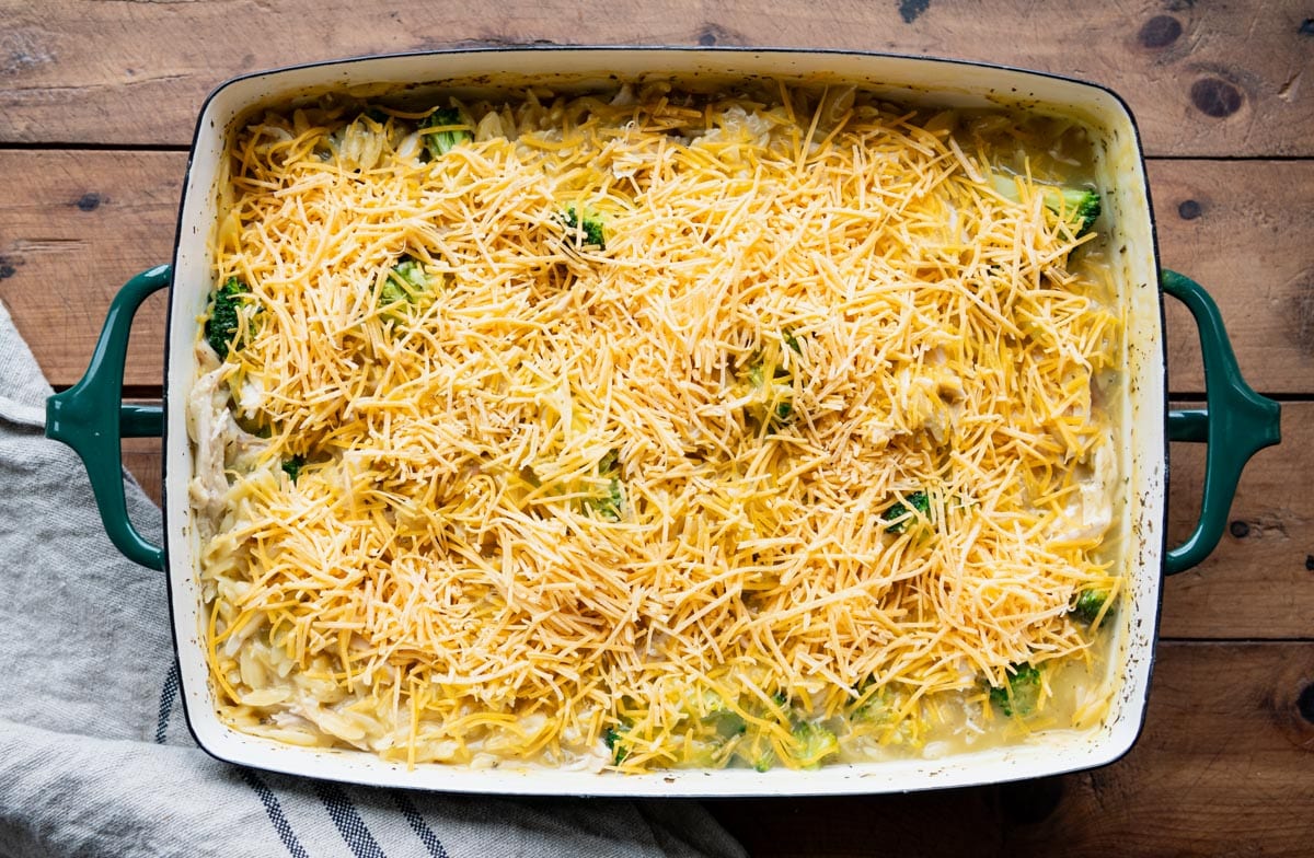 Chicken orzo casserole with cheese on top.