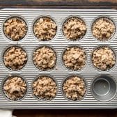 Gingerbread muffins with streusel in a muffin tin before baking.