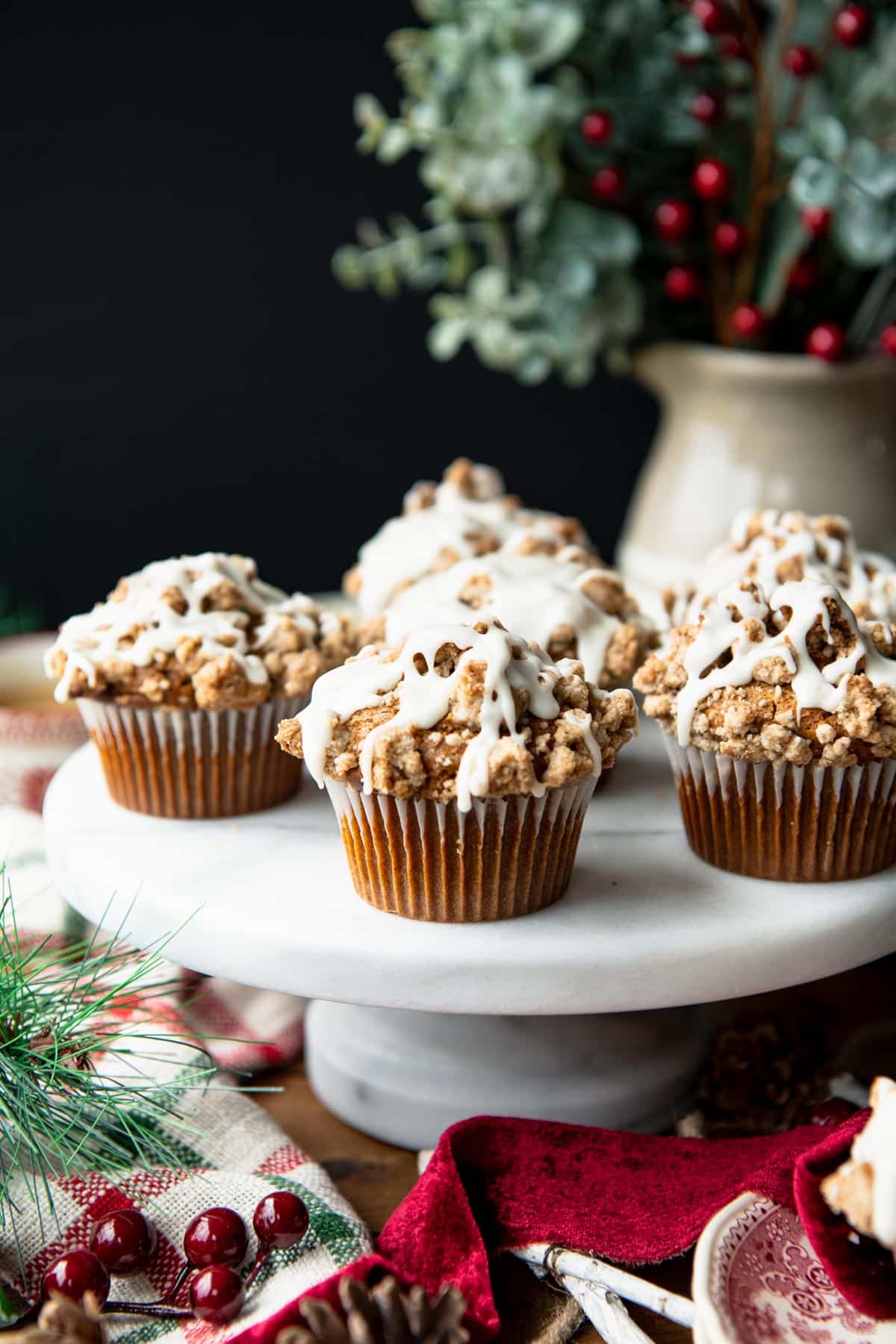 Side shot of the best gingerbread muffins recipe served on a white marble cake stand.