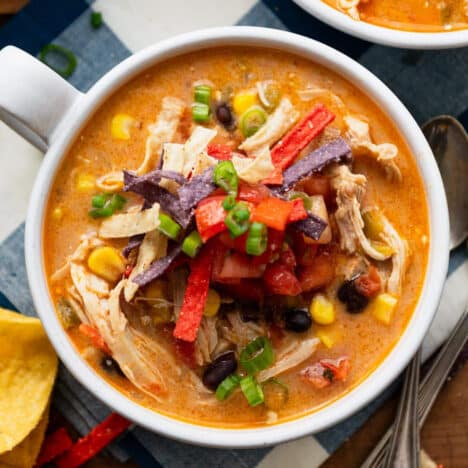 Square overhead shot of a bowl of chicken enchilada soup.