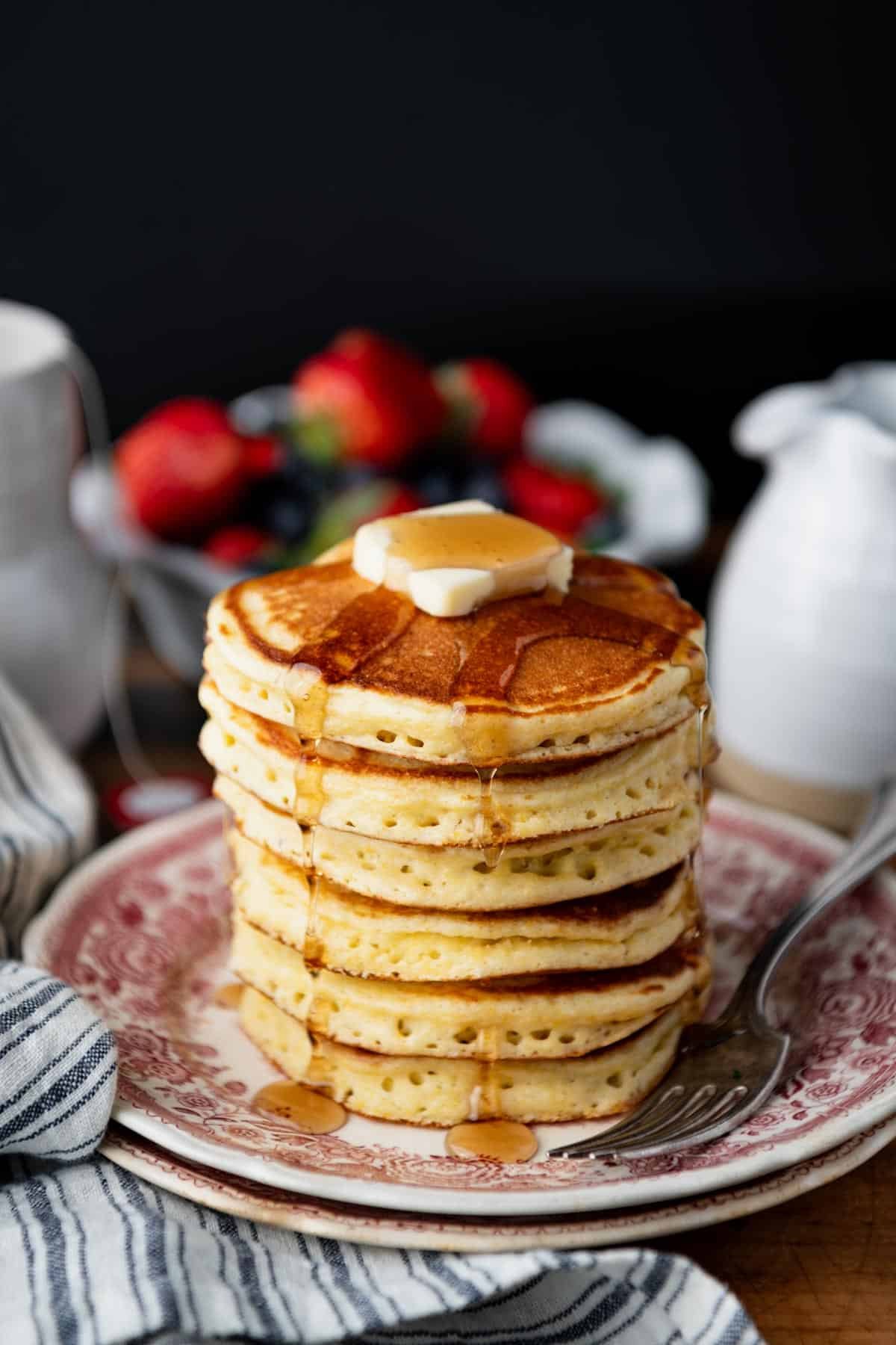 Cornmeal pancakes made with jiffy mix and served on a red and white vintage plate.