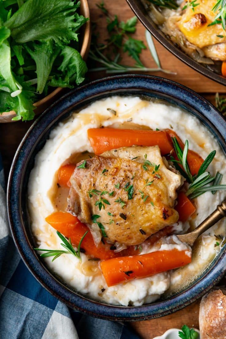 Close overhead shot of braised chicken thighs with mashed potatoes.