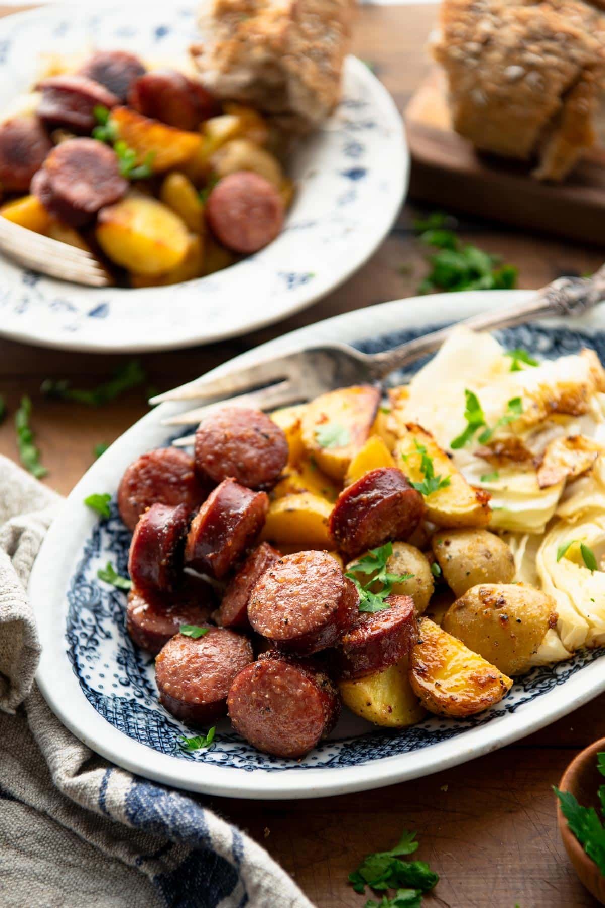 Side shot of a dinner table full of cabbage and kielbasa with potatoes.