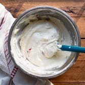 Stirring together creamy pudding filling for a strawberry icebox cake with cream cheese.