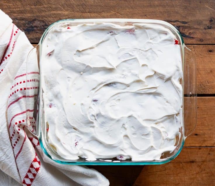 Cool whip spread on top of strawberry icebox cake.