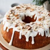 Easy almond pound cake on a plate with almond glaze and toasted almonds on top.