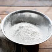 Sifted flour in a metal bowl.