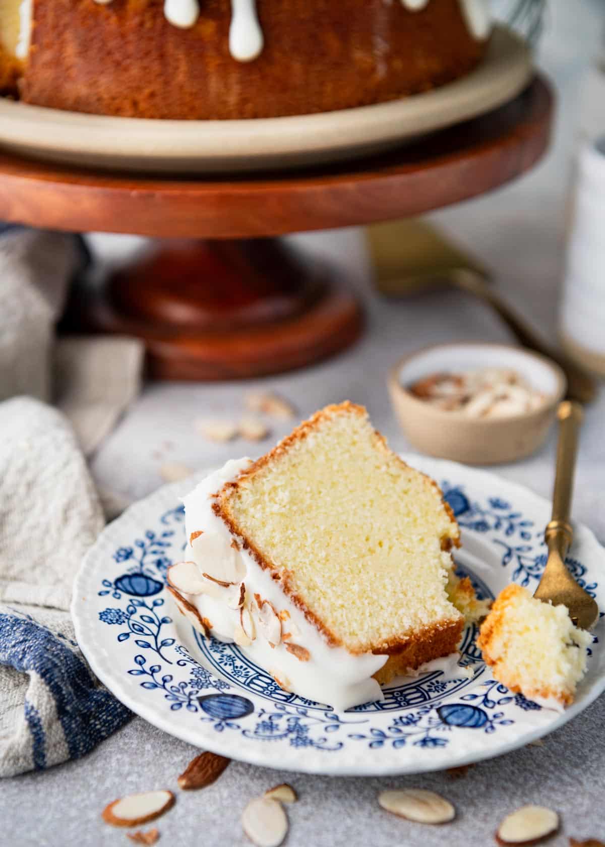 Slice of almond pound cake on a blue and white plate.