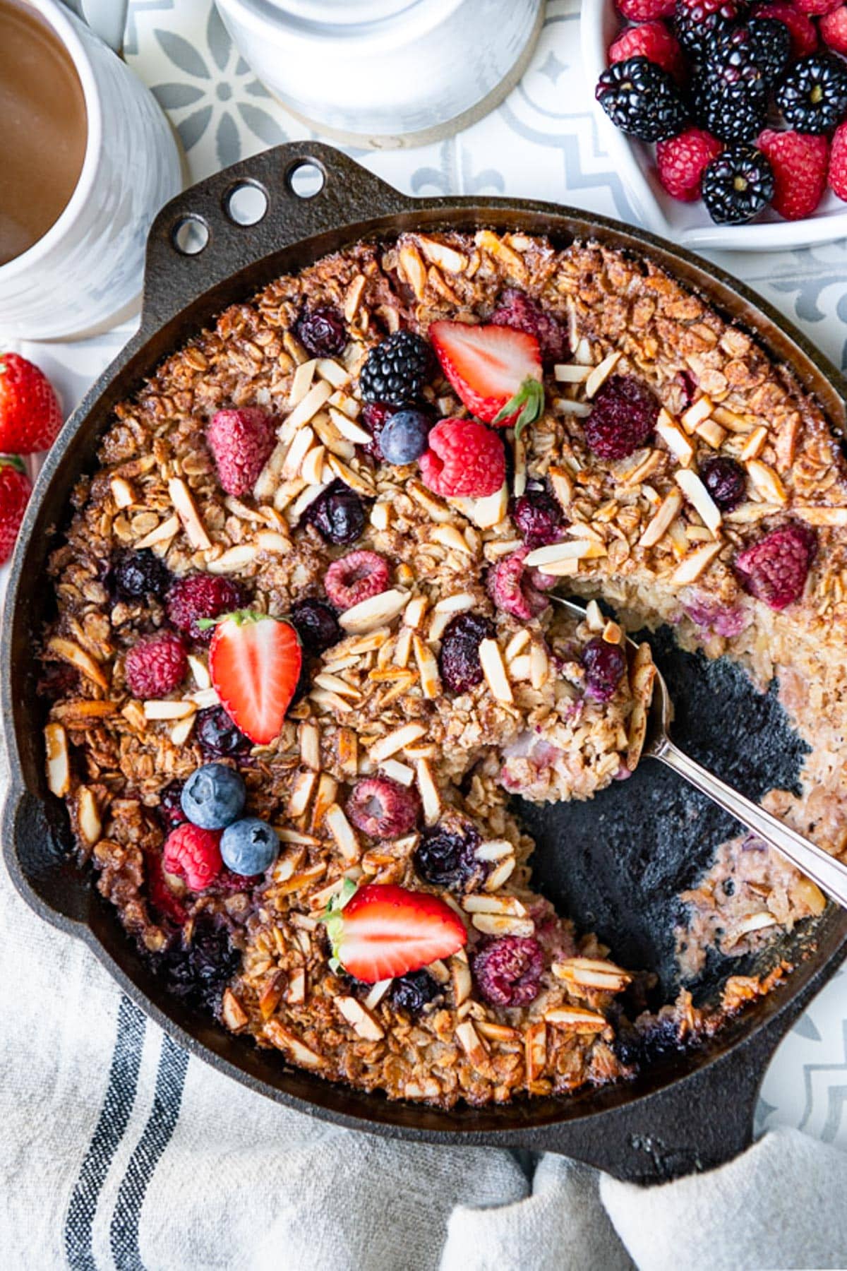 Overhead shot of baked oatmeal with berries in a cast iron skillet.
