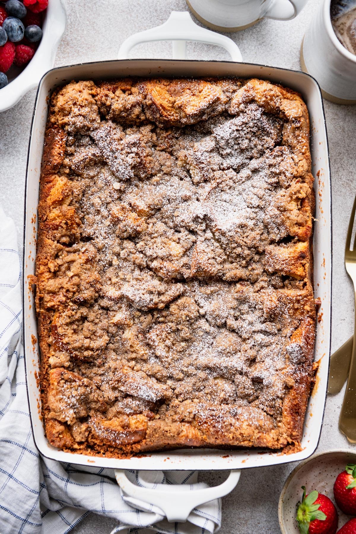 White baking dish with overnight brioche french toast casserole and pecan streusel topping.