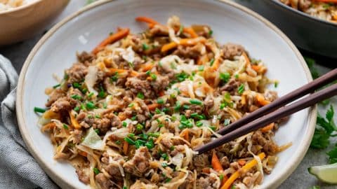 Square side shot of a bowl of egg roll in a bowl with coleslaw mix and ground pork.