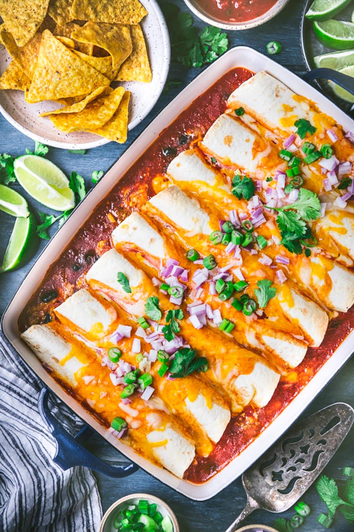 Overhead image of simple ground beef enchiladas on a blue table.