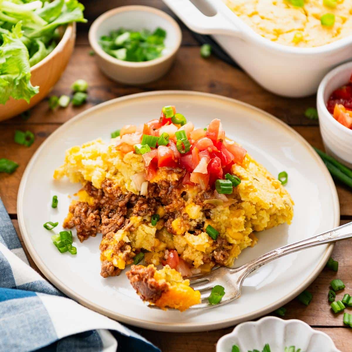 Square side shot of taco cornbread casserole on a white plate.