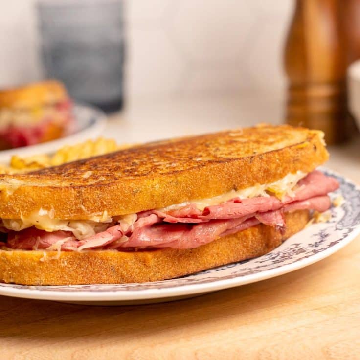Close up square side shot of a classic pastrami reuben.