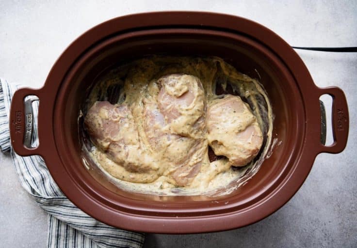 Process shot showing how to make ranch chicken in a slow cooker.
