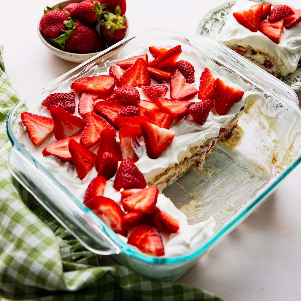 Square side shot of a strawberry icebox cake in a square glass baking dish.