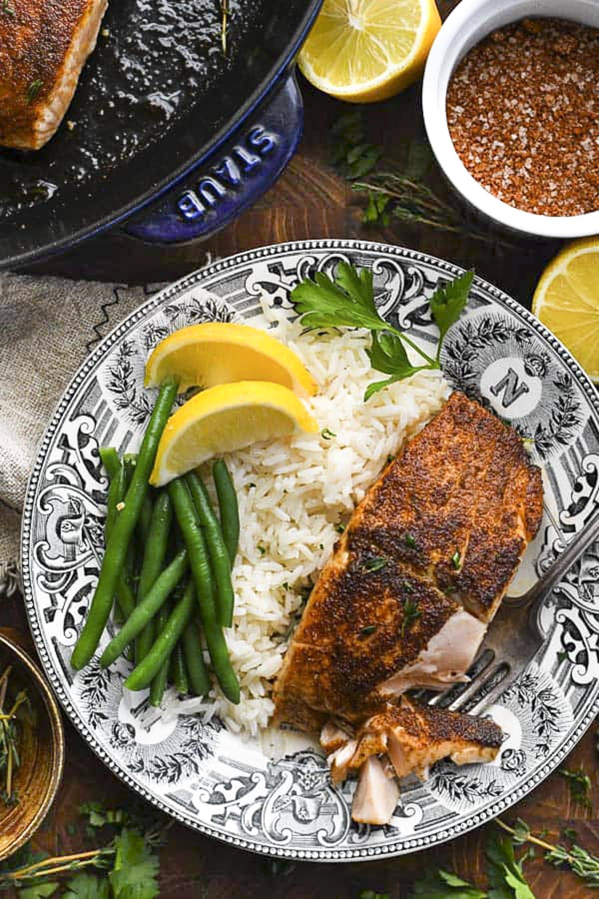 Overhead shot of blackened salmon on a plate with rice and green beans.