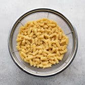 Boiled rotini pasta in a colander.