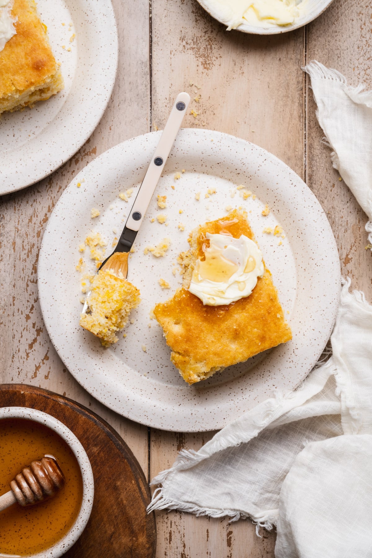 Overhead shot of homemade cornbread with corn on a white plate.