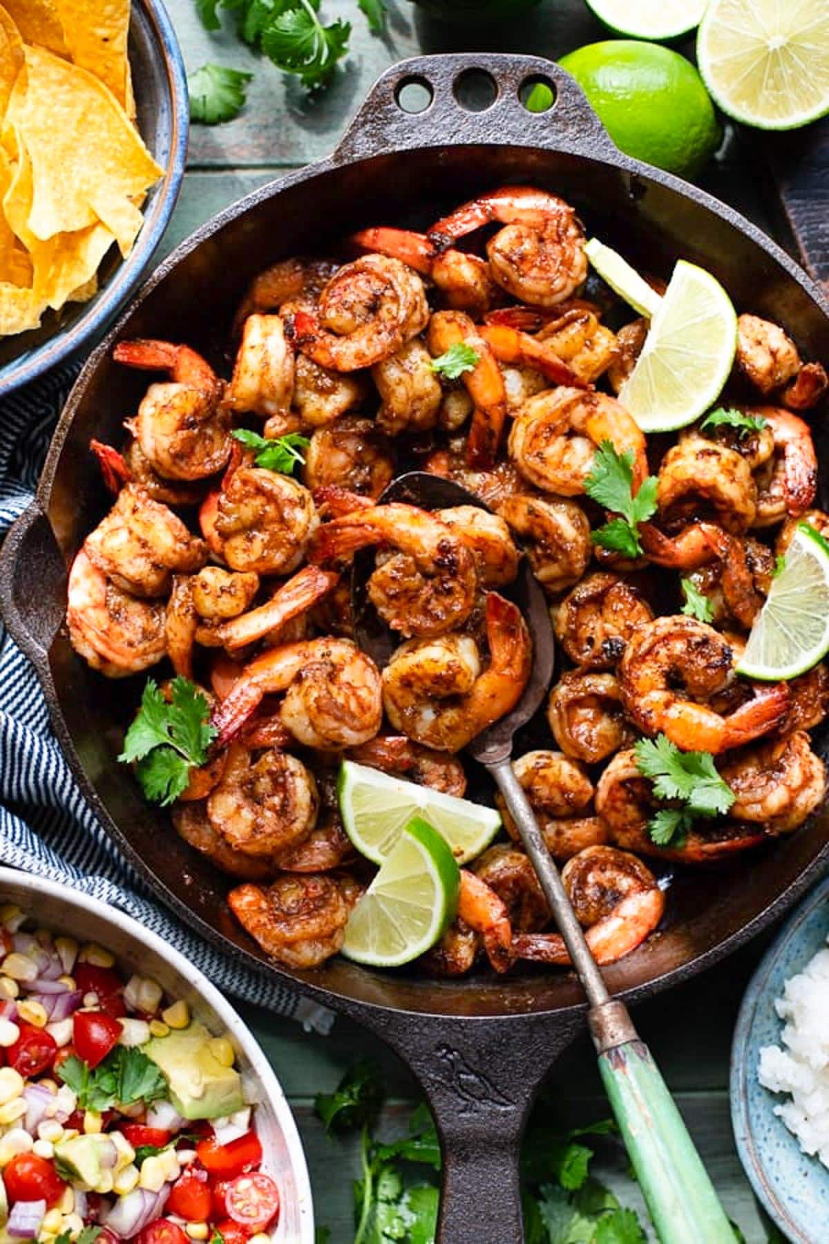 Overhead image of a serving spoon in a Mexican shrimp skillet recipe.