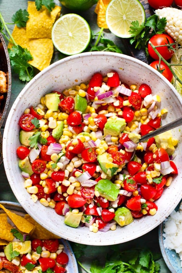 Overhead image of a bowl of fresh tomato, corn, and avocado salad.