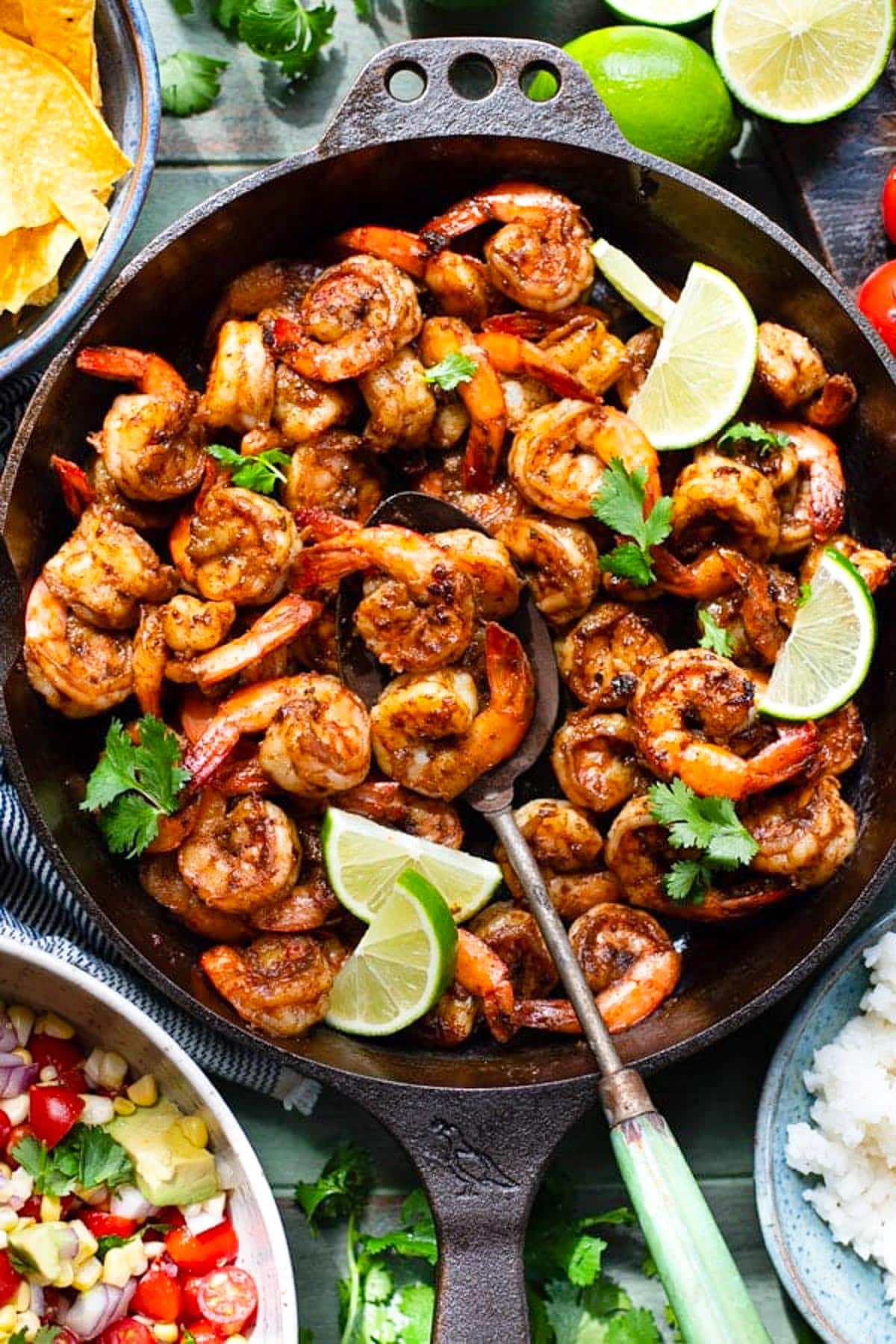 Overhead image of Mexican shrimp in a skillet on a green table.